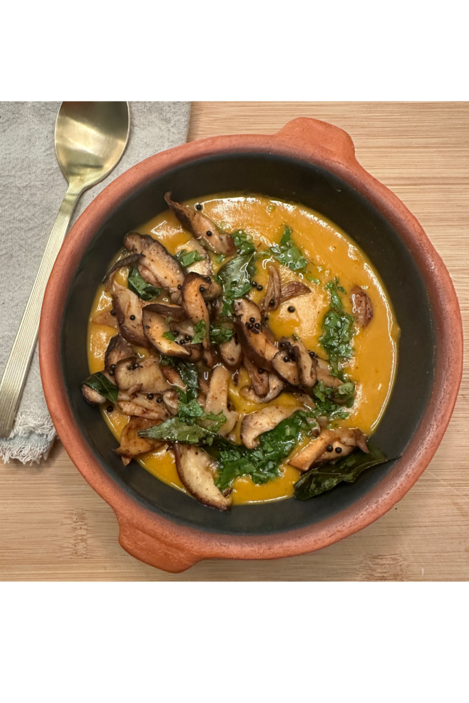 bowl of curried butternut squash soup with mushrooms and cilantro lime dressing