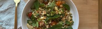 Crispy Rice Salad with Chili crisp dressing in a bowl on a wood cutting board with a napkin and fork next to the bowl.