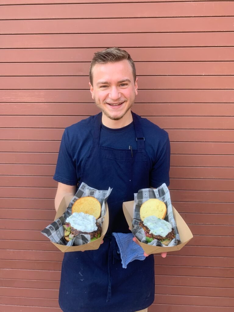 Image of fig lane nutrition's owner., Parker Lane, MS, RDN, holding trays with plant based burgers in both hands.